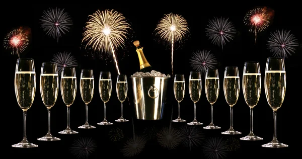 Glasses of champagne with silver ice bucket and fireworks — Stock Photo, Image