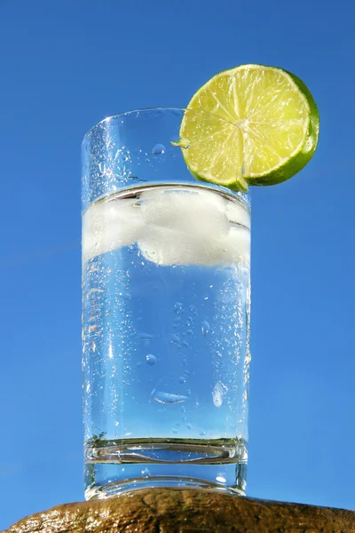 Kallt glas vatten mot en blå himmel — Stockfoto