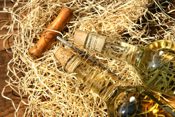 Botellas de vino colocadas sobre paja de embalaje con tornillo de corcho —  Fotos de Stock