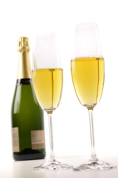 Kieliszki do szampana z butelki na biały — Zdjęcie stockowe