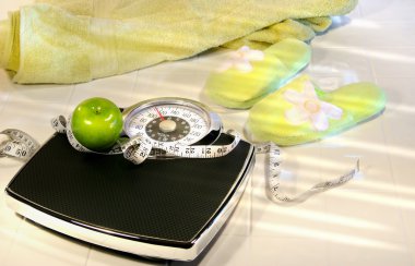 Weight scale on tile floor with towel and slippers clipart