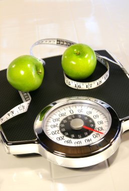 Weight scale with green apples clipart