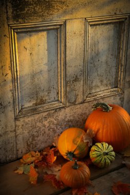 Pumpkins, broom and gourds at the door clipart