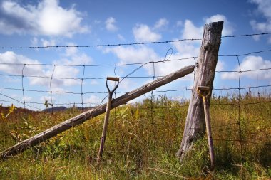 Shovels leaning against the fence clipart