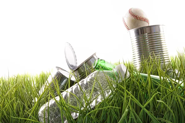 Tomma mat burkar, flaskor och baseball i gräs — Stockfoto