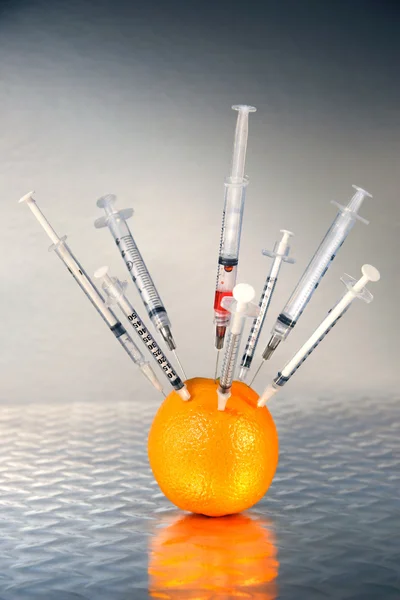 Syringes inserted into an orange — Stock Photo, Image