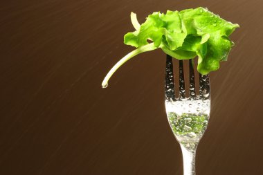 Leaf of lettuce on a fork clipart