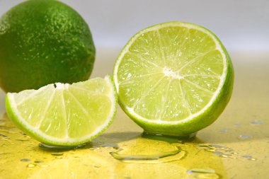 Limes on yellow surface clipart