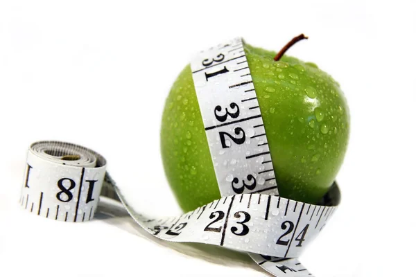 Measurement tape wrapped around green apple — Stock Photo, Image