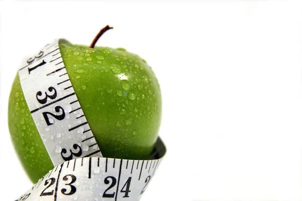 Measurement tape wrapped around green apple — Stock Photo, Image