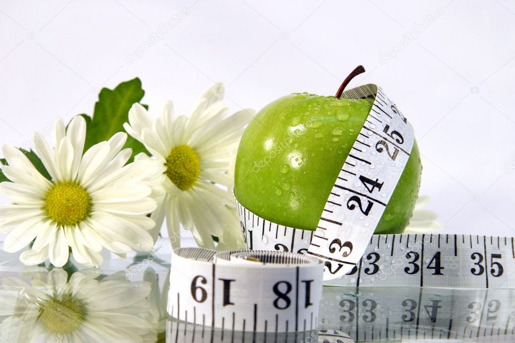 Measurement tape wrapped around green apple