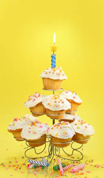 Cupcake con candela blu su giallo — Foto Stock