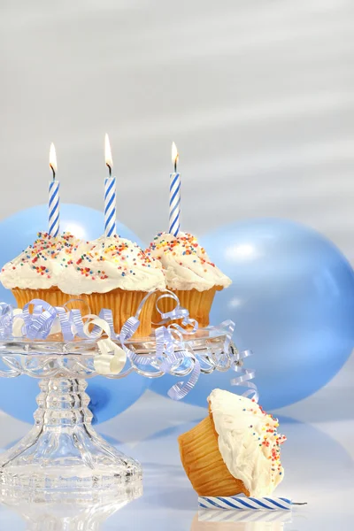 Magdalenas de cumpleaños con velas azules —  Fotos de Stock