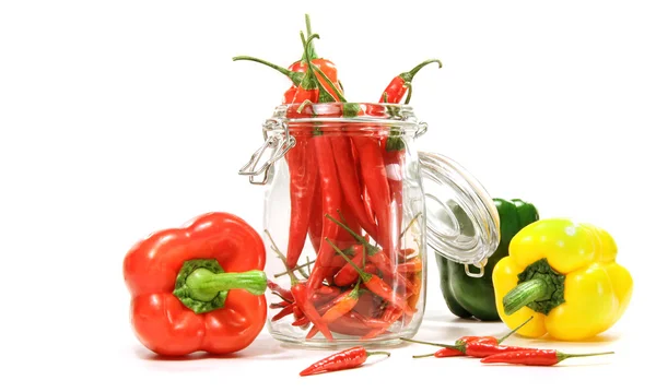 Κόκκινες πιπεριές σε γυάλινο βάζο που απομονώνονται σε λευκό — Φωτογραφία Αρχείου