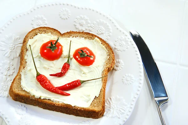 Їжа, організована в смайлик обличчя на бутерброд — стокове фото