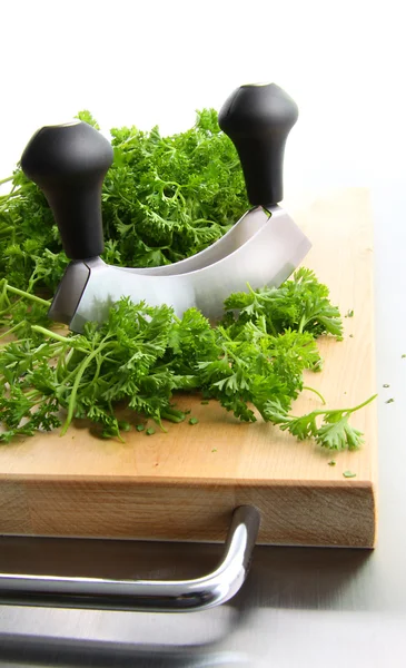 Freshly chopped parsley on wooden cutting — Stock Photo, Image
