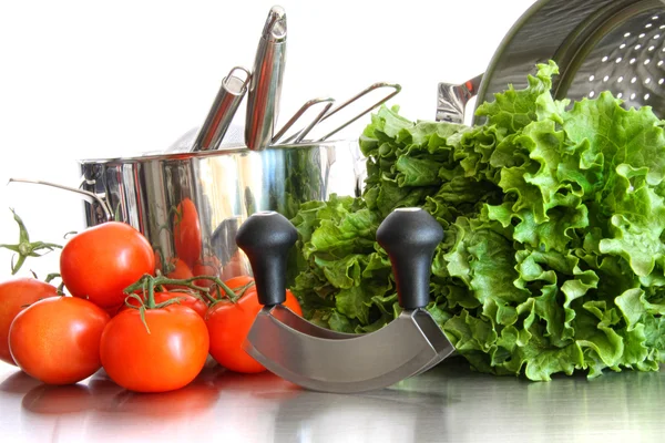 Groenten met keuken potten en gebruiksvoorwerpen op wit — Stockfoto