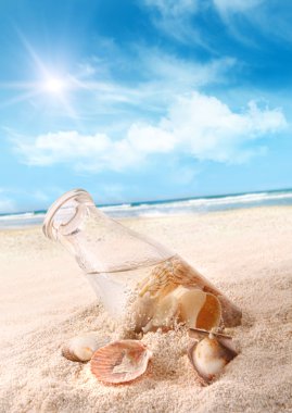 Bottle with seashells in the sand clipart