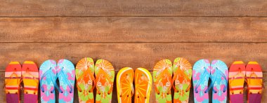 Brightly colored flip-flops on wood clipart