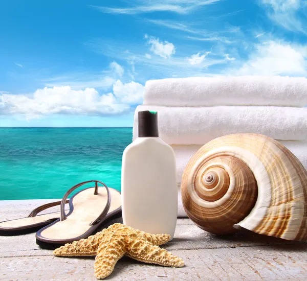 Solskydd lotion och handdukar och ocean scen — Stockfoto