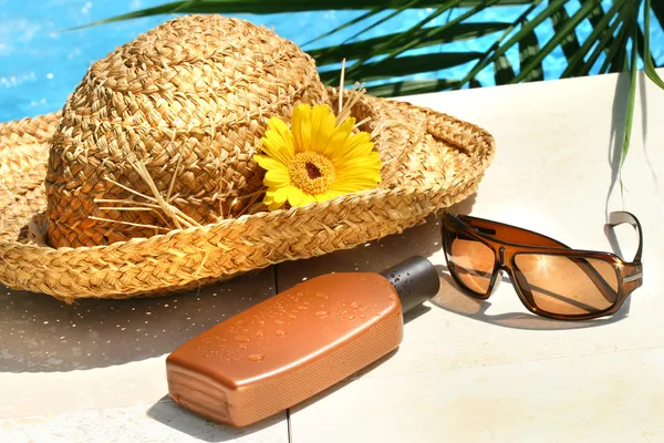 Stro hoed, glazen en zonnebrand lotion — Stockfoto