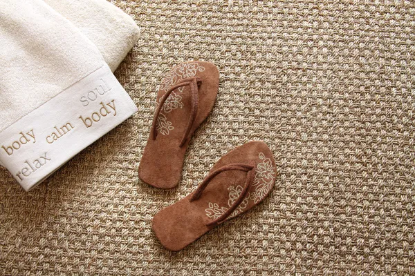 Chanclas con toallas en alfombra de pasto marino —  Fotos de Stock