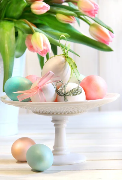 Кольорові яйця з бантами і тюльпанами — стокове фото