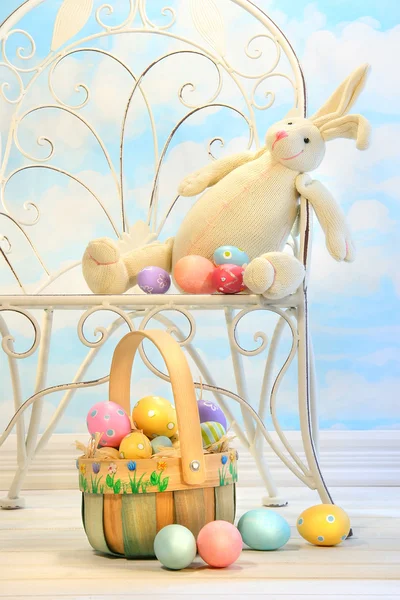 Easter bunny met eieren op stoel — Stockfoto