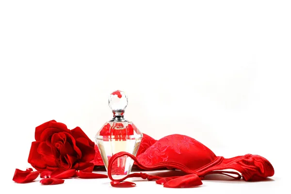 Parfümflasche, Rose und roter Büstenhalter — Stockfoto