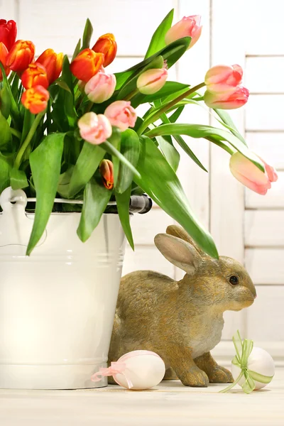 Coelho escondido atrás de um recipiente de tulipas — Fotografia de Stock
