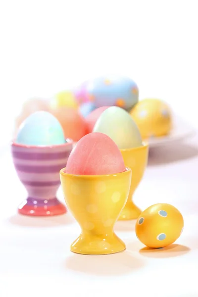 Eier-dopjes met gekleurde eieren op wit — Stockfoto