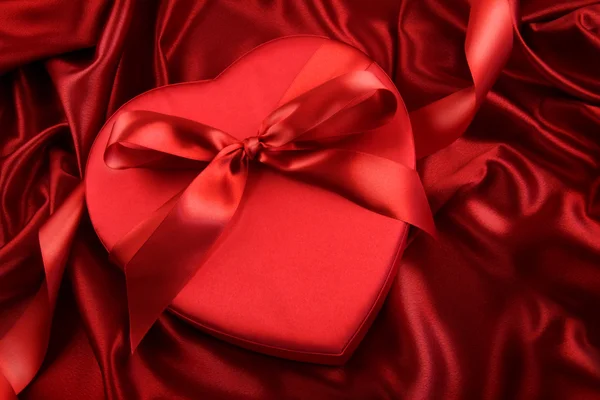赤のサテン上にチョコレートのボックス — ストック写真