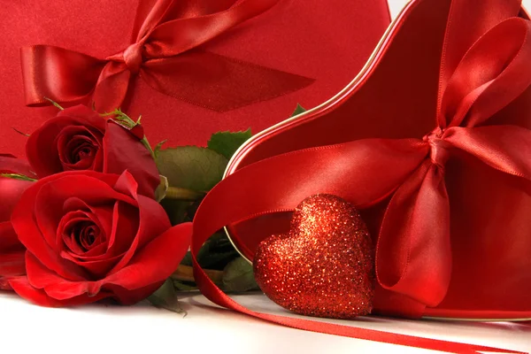 Chocolate boxes with red satin ribbons and roses — Stock Photo, Image