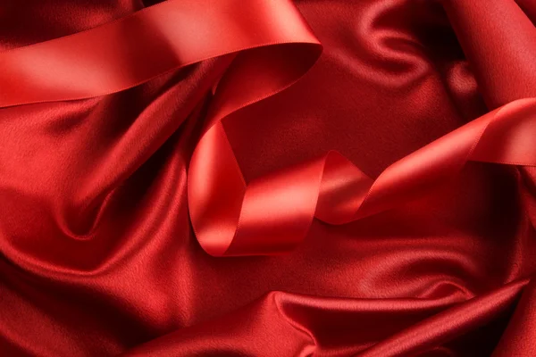 Zengin kırmızı renk kurdele ile saten kumaş — Stok fotoğraf