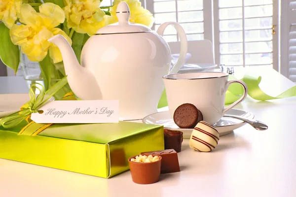 Box of chocolates on table with tea set — Stok fotoğraf