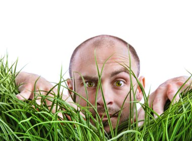 Man peering through tall grass clipart
