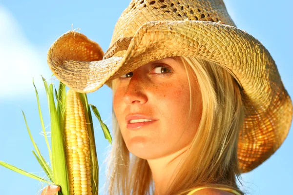 Hermosa joven sosteniendo maíz — Foto de Stock