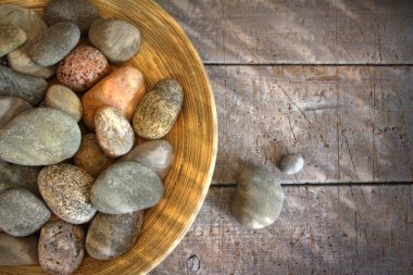 Spa rocks in wooden bowl on rustic wood clipart