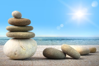 Stack of spa rocks on wood against blue sky clipart