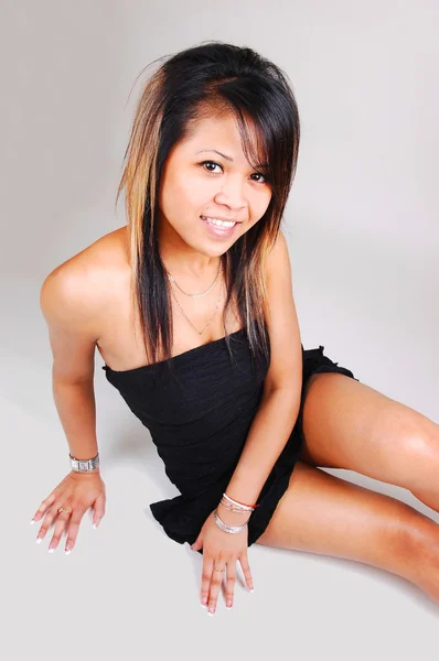 Aziatisch meisje, zittend op de vloer. — Stockfoto