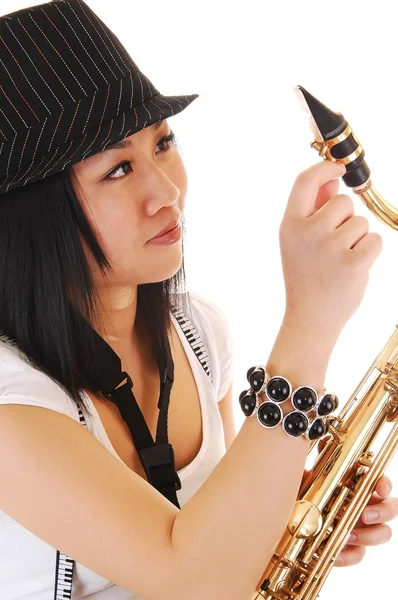 Chinesisches Mädchen repariert das Saxophon. — Stockfoto