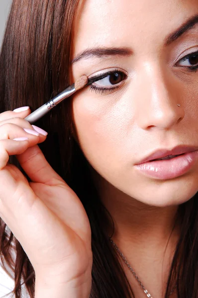 Mujer joven poniendo maquillaje . —  Fotos de Stock