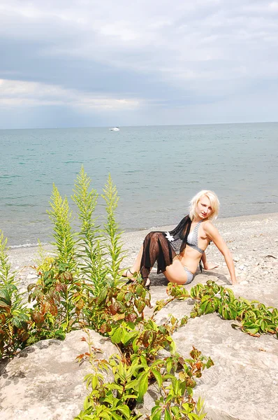 Bikini girl op rotsachtige strand. — Stockfoto