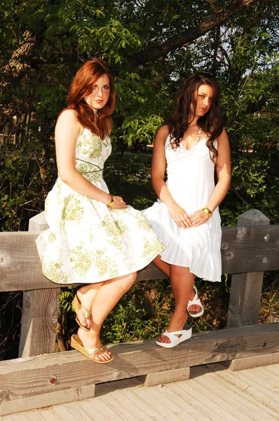 Two sisters sitting on bridge. — Stock Photo, Image