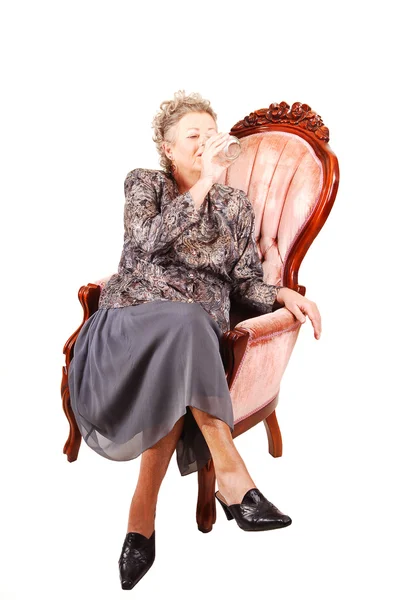 ピンクの肘掛け椅子の年配の女性. — ストック写真