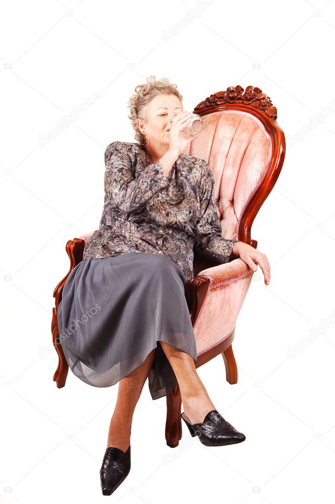 Senior woman in pink armchair.