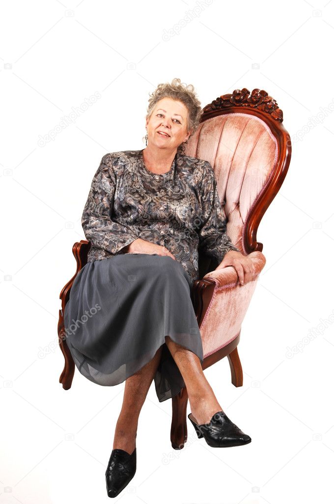 Senior woman in pink armchair.