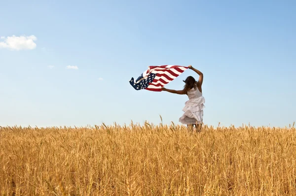 Mujer sosteniendo una bandera en un campo de centeno . —  Fotos de Stock
