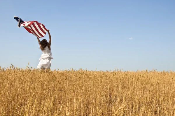 Mulher segurando uma bandeira em um campo de centeio . — Fotografia de Stock