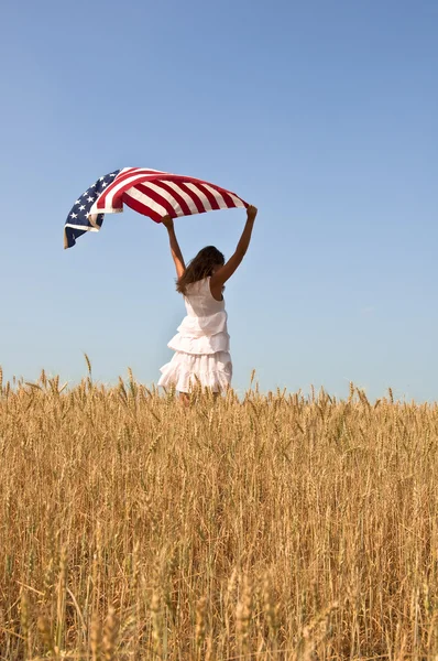 Mujer sosteniendo una bandera en un campo de centeno . —  Fotos de Stock